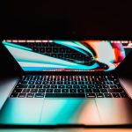 Close-up of a laptop with a colorful screen in low light